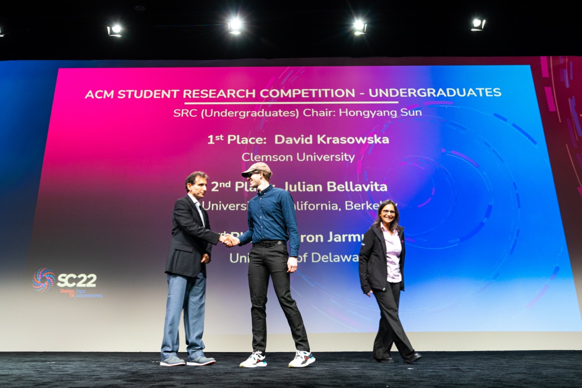David Krasowska accepting first place in the ACM Student Research Competition on stage at SC22
